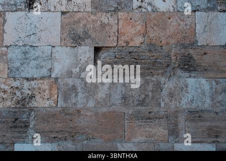 Stone wall texture background, weathered masonry surface detail, natural stone blocks pattern, rustic architectural material, neutral earthy tones Stock Photo