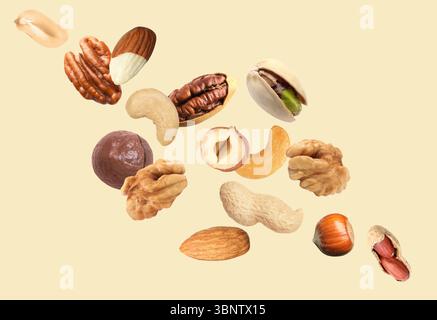 Peanut and other nuts flying on beige background Stock Photo
