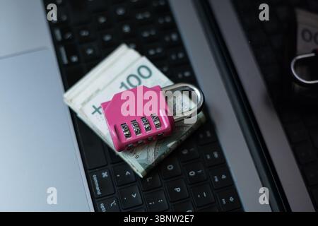 Secure Your Cash And Data. Stack Of Zloty Bills Locked With A Pink Padlock On A Laptop. Symbol Of Cyber Protection And Financial Safety In The Digital Stock Photo