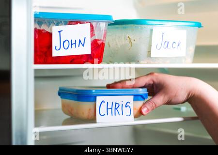 Meal prep containers in office refrigerator. Ideal for time management content, and efficient workspace setups. Stock Photo