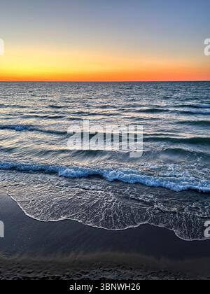 Sunset gradient from blue to orange above blue ocean water. Meditation content, moody aesthetics Stock Photo