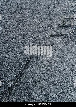 Detailed close-up of new asphalt surface, featuring rough texture and dark color, emphasizing the quality and strength of road materials used in const Stock Photo