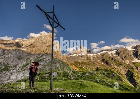 Sepp Zurfluh took over the Hobiel Alp from his father in 1970. He has already spent 69 summers here. In the evening, he calls out the Alpsegen, also known as the Betruf, in all four directions for comprehensive protection from danger. Evening ritual in the alpine landscape at the Hobiel-Alp, near Engelberg, Switzerland. The eldest family member performs the traditional call to prayer in front of all those present. This tradition shows the combination of deep piety and the impressive nature of the Swiss Alps. Hobiel, Engelberg, Uri, Switzerland Stock Photo