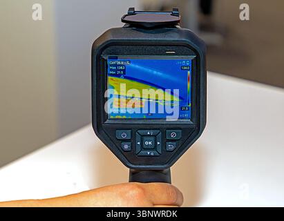 Male hand holding thermal camera tool in the air Stock Photo
