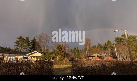 Rain clouds and rainbow over Finnish residential area, Finland Stock Photo