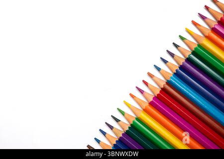 vibrant collection of colored pencils is neatly aligned on a blank white surface, showcasing a variety of hues perfect for drawing, coloring, and craf Stock Photo