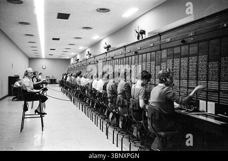 Photograph taken on January 27, 1959, by Marion S. Trikosko, shows a row of women telephone operators working at the U.S. Capitol switchboard in Washington, D.C. On average, they handled 50,000 calls per day, connecting members of Congress and the public during a busy era of legislative activity. Stock Photo