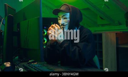 Lviv, Ukraine - June 03, 2024: Hacker man anonymous dangerous computer pc criminal stealing information online datum hooded mysterious person coding Stock Photo