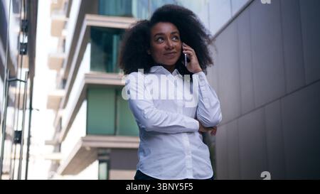 African American woman talking mobile phone smartphone laughing smiling gadget communication conversation call female girl employer businesswoman Stock Photo
