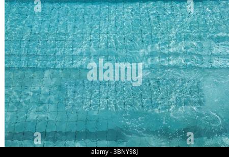 Mosaic tiles and built-in steps are showing through rippling water under sunlight in vector art Stock Photo