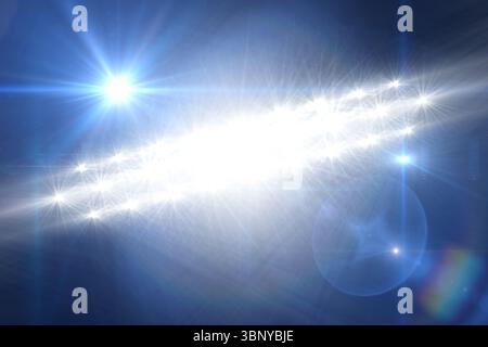 Featuring starburst lights emitting lens flares over blue gradient backdrop creating light streaks Stock Photo