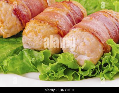 food still-life, Pork cutlets wrapped in bacon on white Stock Photo