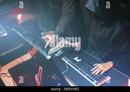 Hacker in dark room using keyboard stealing data on internet Stock Photo