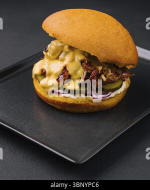 food still-life, Delicious burger with torn meat on black tray Stock Photo