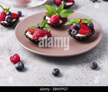 food still-life, Chocolate ganache tarts with fresh berries Stock Photo