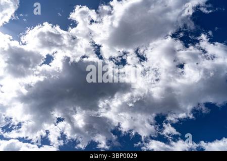 Fluffy clouds float across a vibrant blue sky in Altafulla, Tarragona, creating a scenic and atmospheric view. Stock Photo