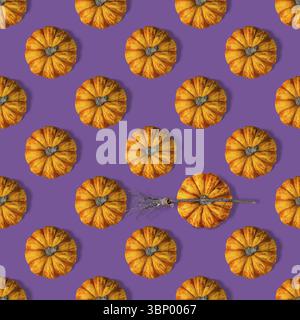 An orange mini pumpkin lies on purple background, seamless pattern, Halloween decor Stock Photo