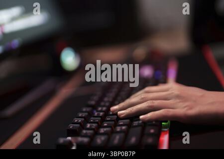 Hacker in dark room using keyboard stealing data on internet Stock Photo