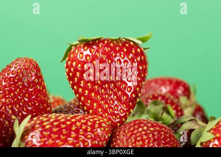 Pile of fresh ripe strawberries on a green background Stock Photo