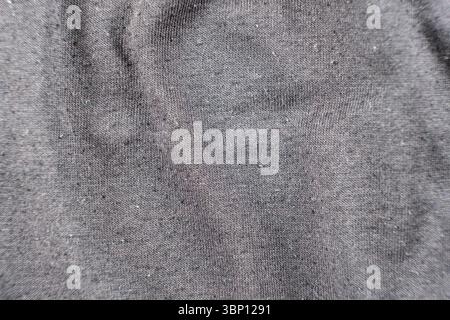 Old worn-out cotton fabric, pilling on a surface. Stock Photo