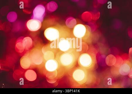 Festive blurred Christmas background, shining pink and yellow lights. Stock Photo