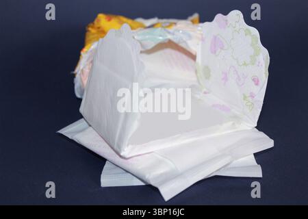 Woman sanitary napkins on dark blue background. Stock Photo