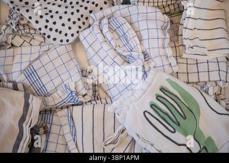 organized linen drawer, folded kitchen textiles and dish towels, natural cotton and linen fabrics, neutral color palette, cozy home organization Stock Photo