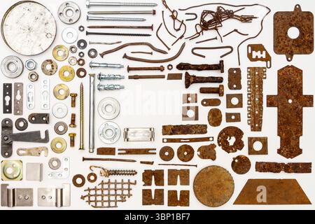 A group of various old and new bits and pieces arranged on white. Old rusty nuts, bolts, nails and other parts flay lay on white background. Stock Photo