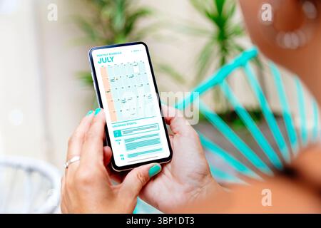 Woman looking the calendar app on mobile phone at the morning for planning the day. Digital schedule concept. Stock Photo