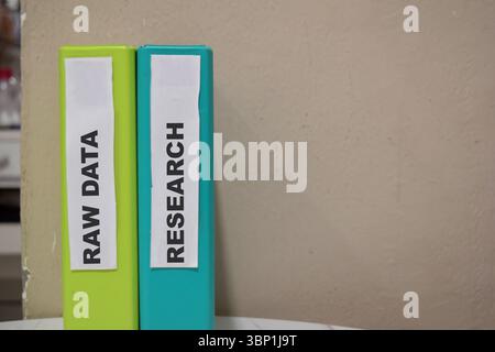 Folders with the label Raw data and research. Business management concept Stock Photo