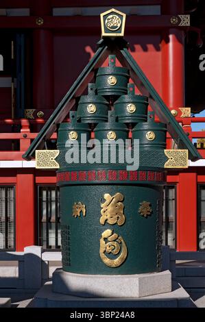 Stack of six green traditional wooden fire buckets under a triangular roof seen here in front of Sensoji Temple, Asakusa, Tokyo, Japan. Stock Photo