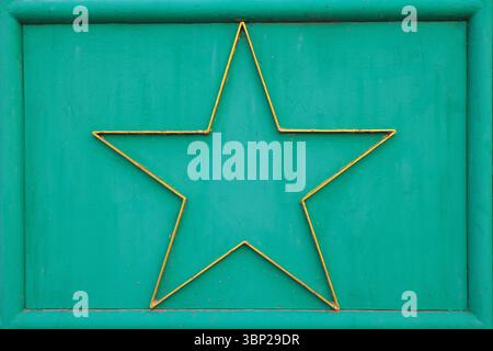 Vintage decor Green metal background with gold five-pointed star in frame. Vintage industrial texture, perfect for design, decor, and creative layout. Stock Photo