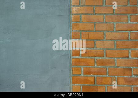 Interior design texture Horizontal split background of smooth grey cement wall and red brick block pattern perfect for abstract design or text overlay Stock Photo