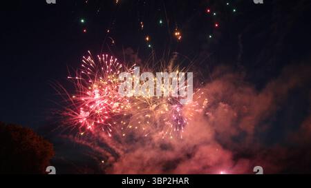 Bright and colorful fireworks exploding against the dark night sky, creating a festive atmosphere during a celebration Stock Photo
