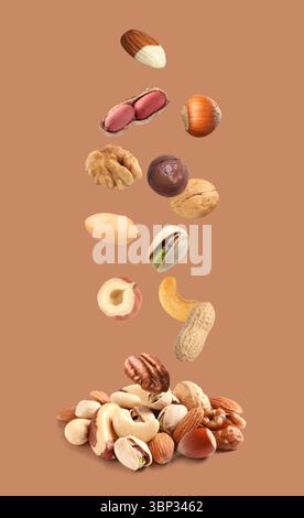 Peanut and other nuts falling on brown background Stock Photo