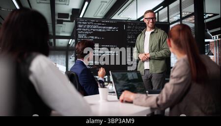 Technician Leading Software Presentation At Business Meeting With Diverse Team. Stock Photo