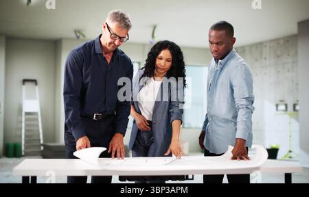 Young Black Couple Meeting With Hispanic Architect For Home Renovation. Stock Photo