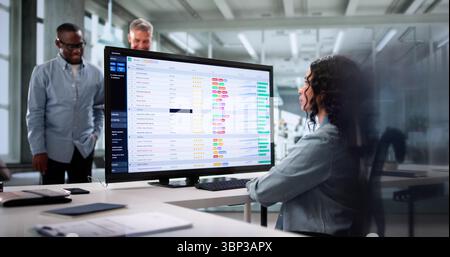 Diverse Team Of Professionals Using Spreadsheets To Analyze Data Together. Stock Photo