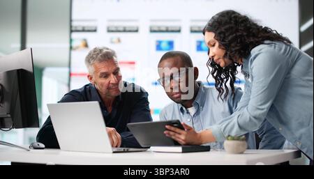 Diverse Team Of UI Designers Collaborating On Mobile App UX. Stock Photo