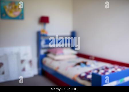 Defocused image of bed against wall in room Stock Photo