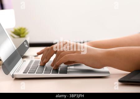 Woman with laptop using web search engine in office Stock Photo