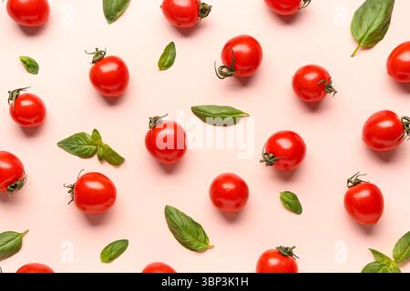 Fresh cherry tomatoes and basil on pink background Stock Photo