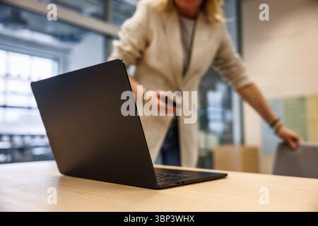 Businesswoman leader is connected for online business meeting or web conference. Laptop on desk in modern office Stock Photo
