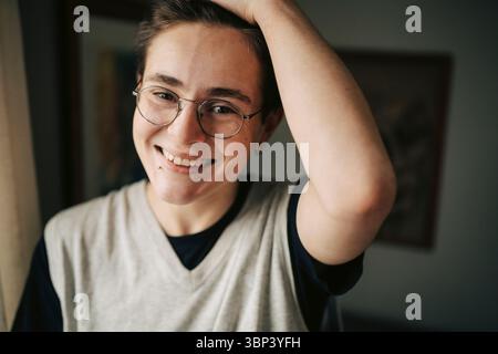 Portrait of happy young man with hand in hair Stock Photo