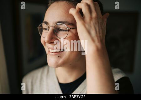 Smiling young man with piercing looking away Stock Photo