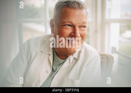 Smiling senior man with gray hair looking away Stock Photo