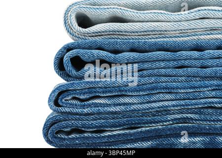 Pile of folded textiles, various shades of blue jeans fabric isolated on white background. Denim cloth stacked in store setting, different textures an Stock Photo