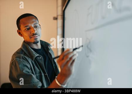 Male entrepreneur writing ideas on screen with digitized pen in meeting room Stock Photo
