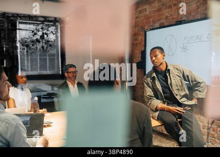 Businessman discussing ideas with colleagues in team meeting at office Stock Photo