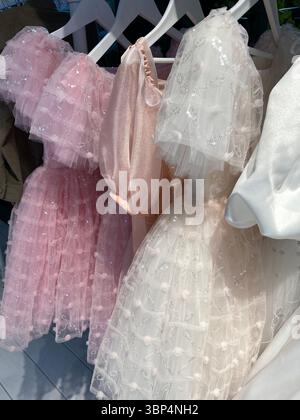 Pink and white dresses with sequins creating a delicate and textured background Stock Photo